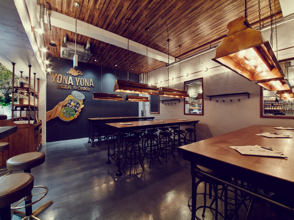 YONA YONA BEER WORKS吉祥寺店、壁面によなよなエールを持った手のグラフィックが大きく描かれたゆとりある店内