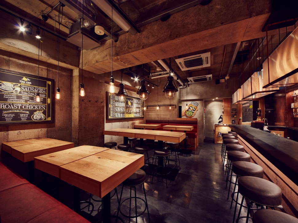 YONA YONA BEER WORKS青山店、打ち放しコンクリートの壁と木のテーブル印象的な店内