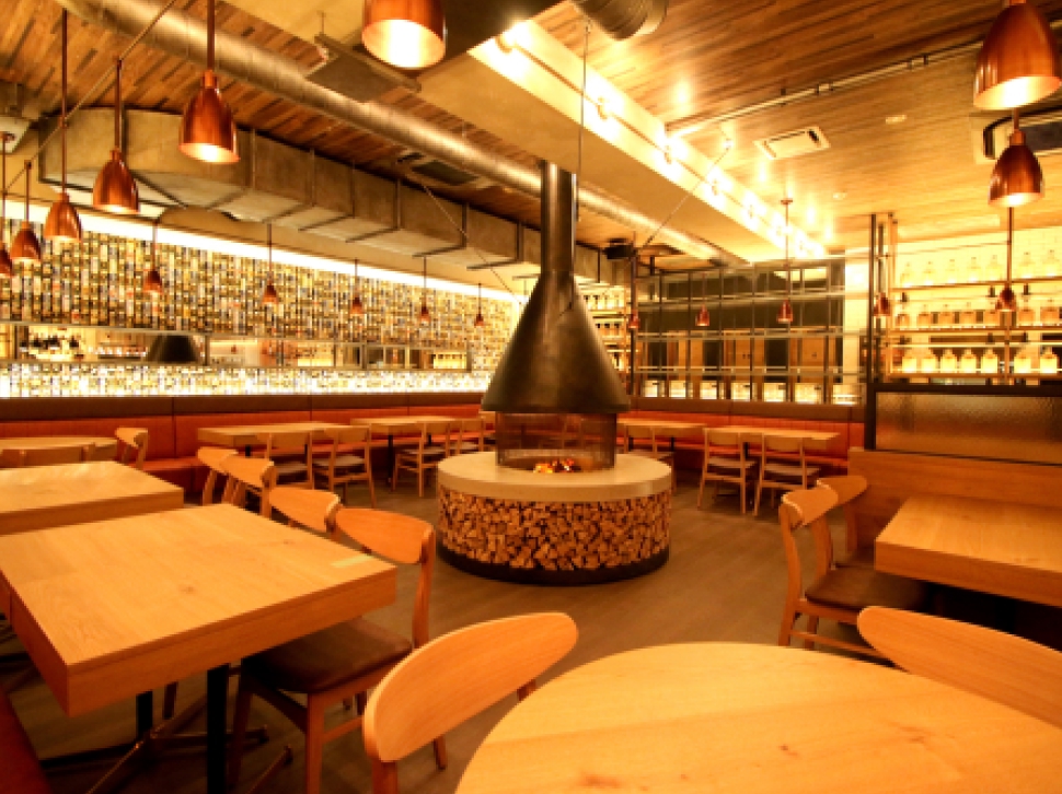 YONA YONA BEER WORKS新宿東口店、テーブルと椅子が並び壁一面を無数のビール缶が覆う店内