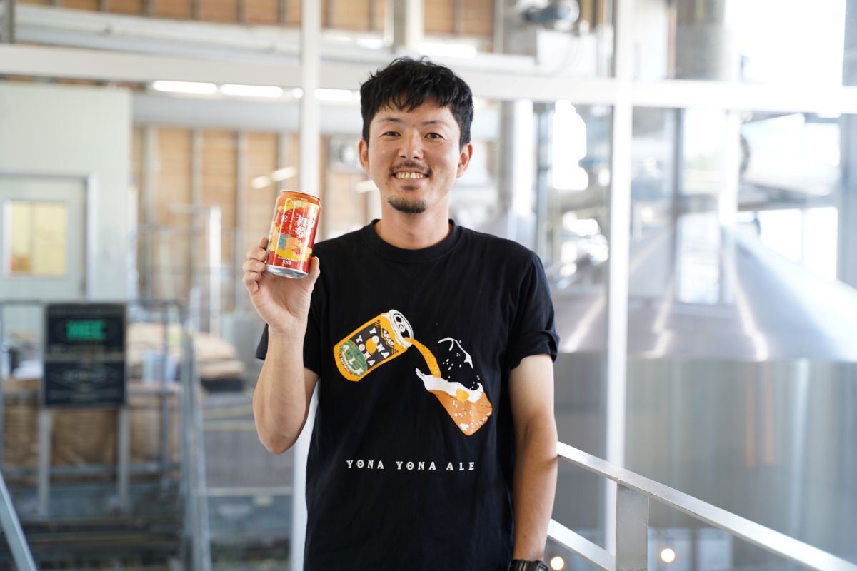担当ブルワーいしぼうがビールグラス片手に持っている様子