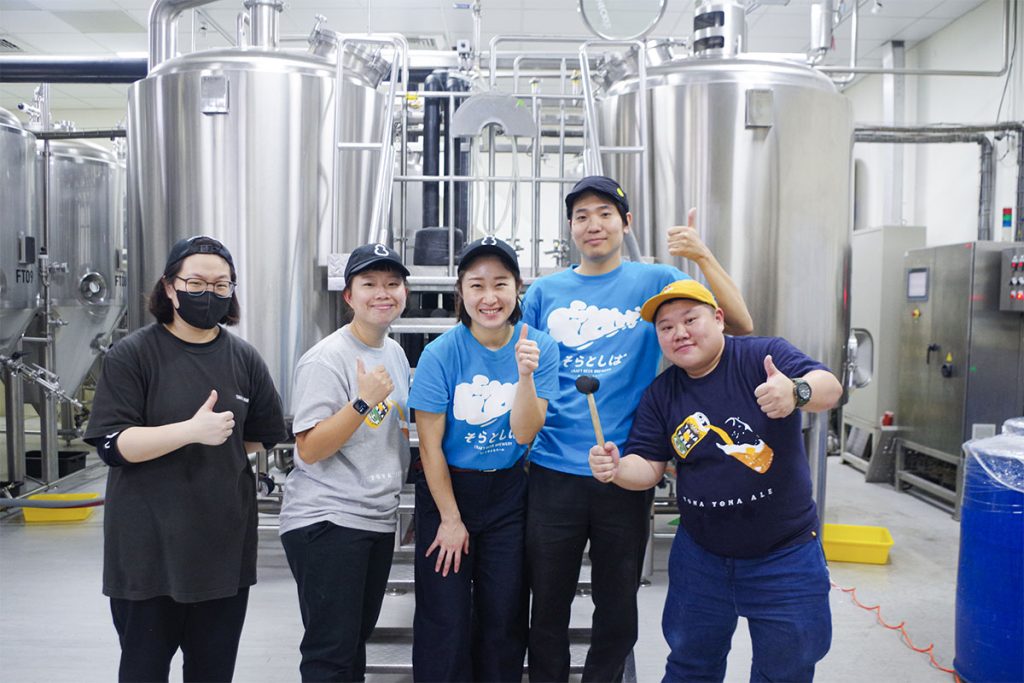 Taihu Brewingの醸造所内でブルワー5人が集合写真を撮影した様子