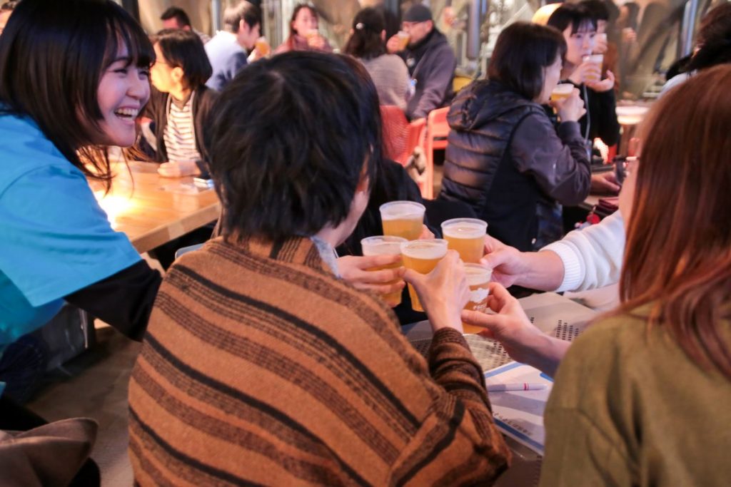 2025年開催の「そらとしば忘年会」にてスタッフと参加者が乾杯している様子