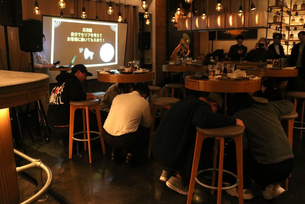 参加者が机の下に隠れている様子