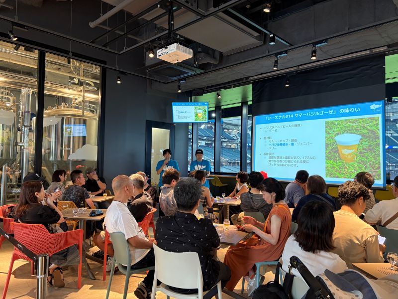 過去に実施したビールの先行開栓イベントにて、ブルワーの話を参加者が聞いている様子