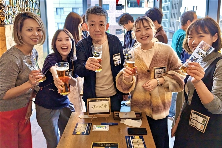 飲み会イベント「宴」の参加者とスタッフがカメラに向かって乾杯している様子